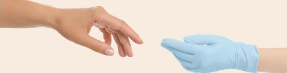 A bare hand reaching toward a blue-gloved clinician's hand